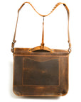 Bacula Messenger bag in full leather construction (structured black leather, pull-up and smooth finish), reinforced with military-grade quick-release buckles and gunmetal rivets at stress points, hardware detail