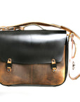 Bacula Messenger bag in full leather construction (structured black leather, pull-up and smooth finish), reinforced with military-grade quick-release buckles and gunmetal rivets at stress points, front view