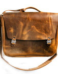 Bacula Messenger bag in full leather construction (structured black leather, pull-up and smooth finish), reinforced with military-grade quick-release buckles and gunmetal rivets at stress points, interior compartment