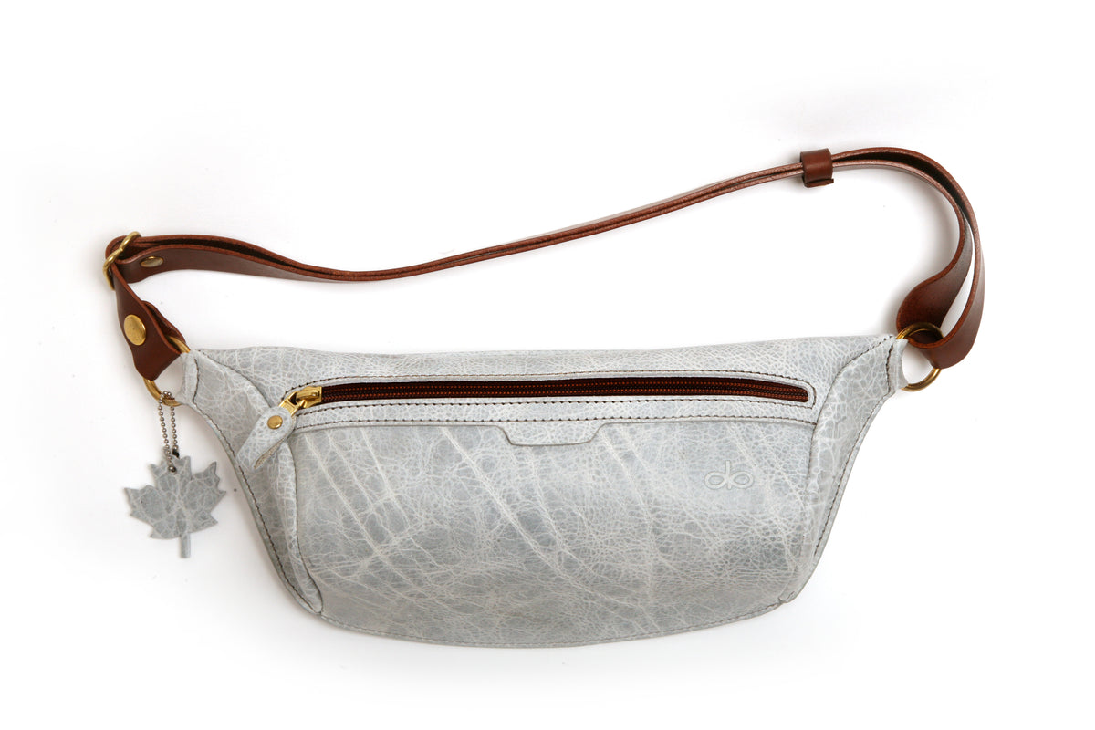 A gray leather shoulder sling bag with a rear pocket, adjustable shoulder strap, and a snap-secured buckle.