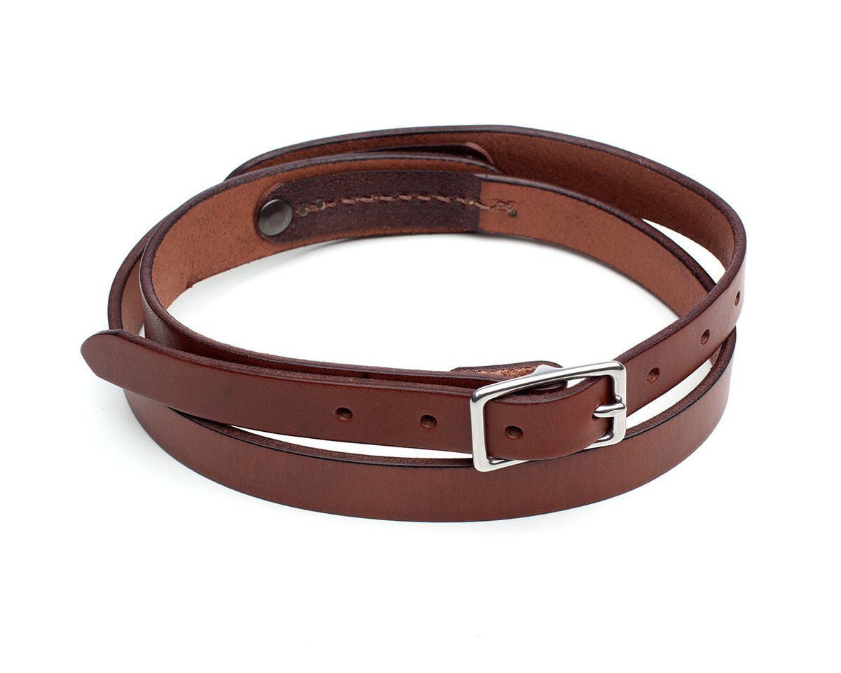 TRIO slim belt in leather with a harness-stitch detail, laid flat, full length