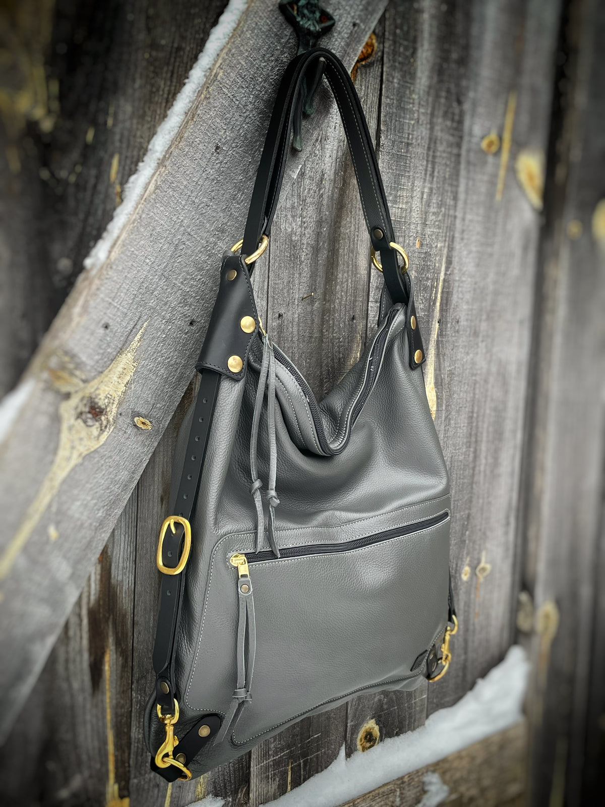 VILLA SAK leather backpack in grey with brass hardware, side view