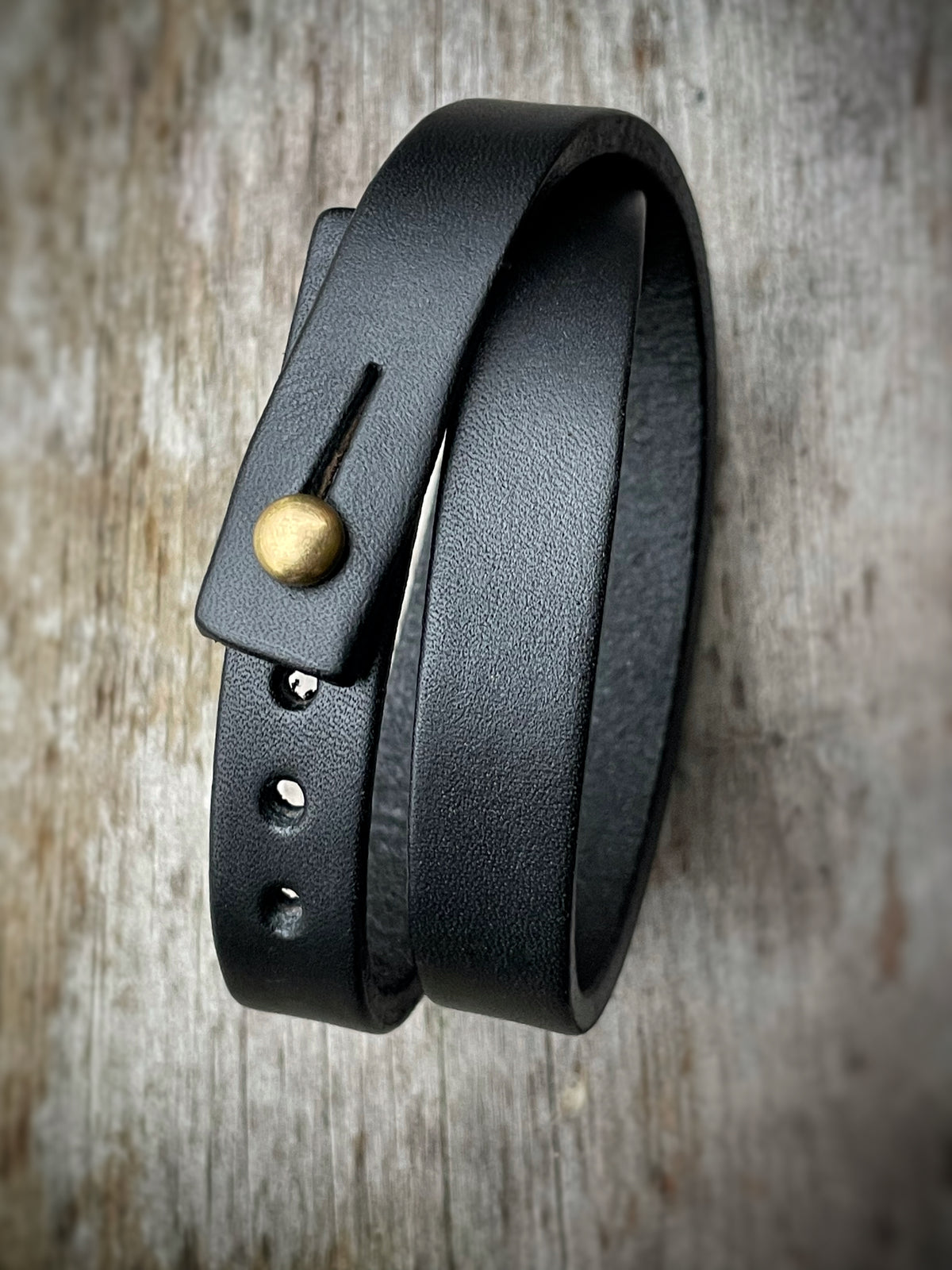 Double wrap cuff in 8oz English bridle leather with stainless-steel hardware, close-up detail